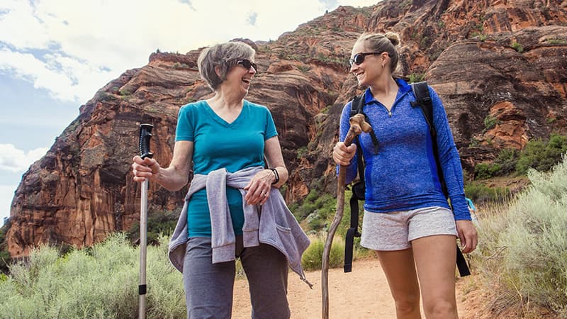 Two women hiking a red-rock canyon
